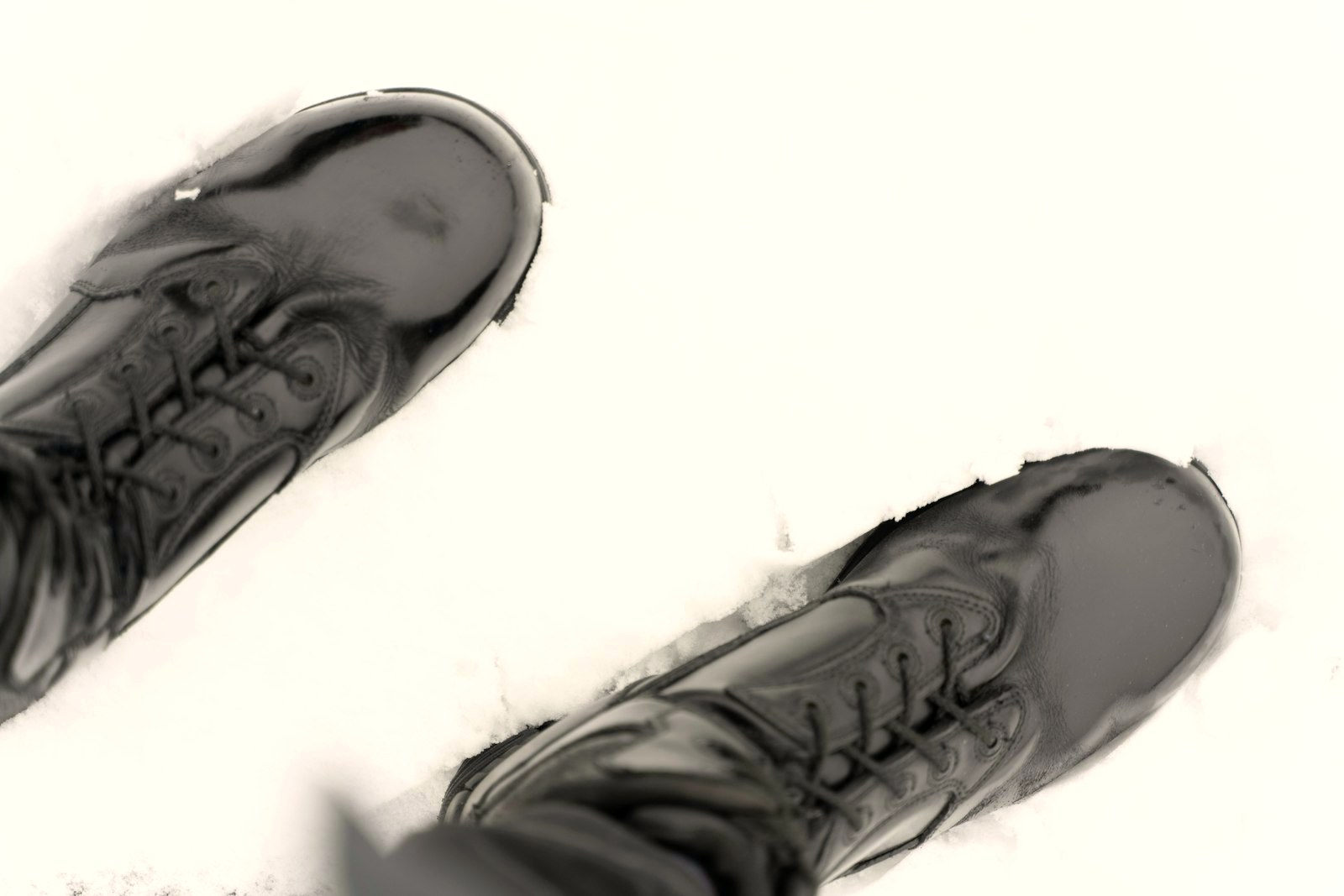 Black boots seen from above, standing in snow