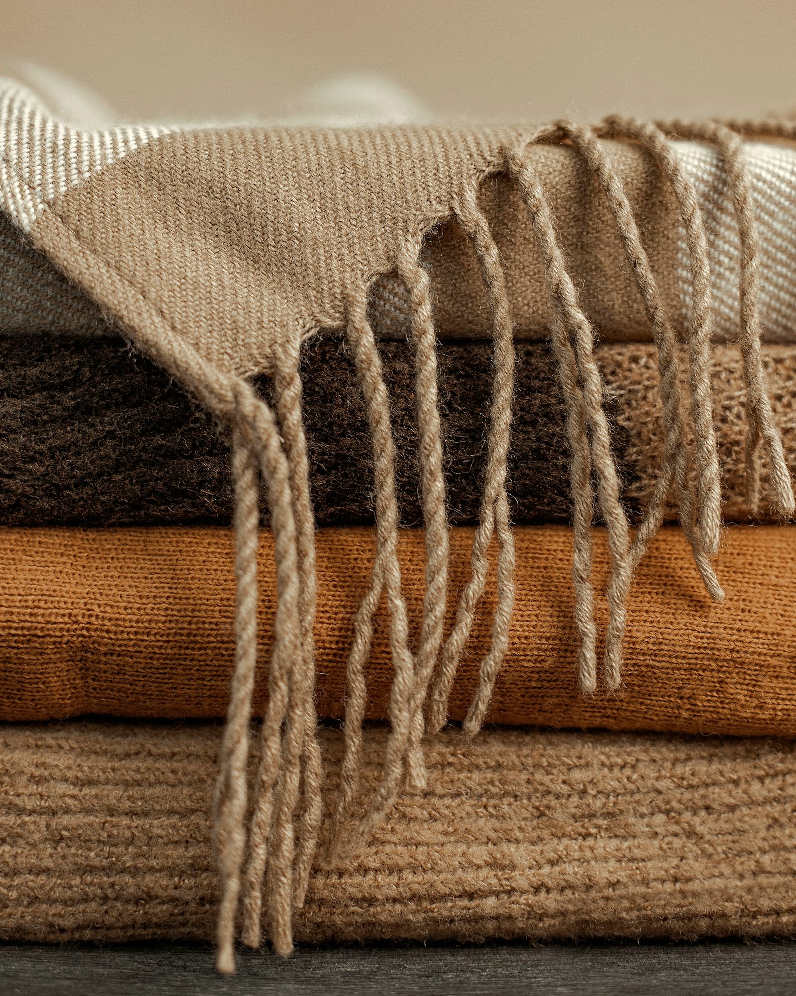 Folded knits with a fringed scarf in winter tones