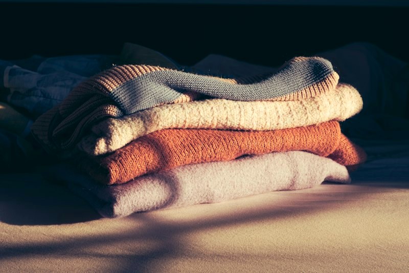 Folded knitwear in window light