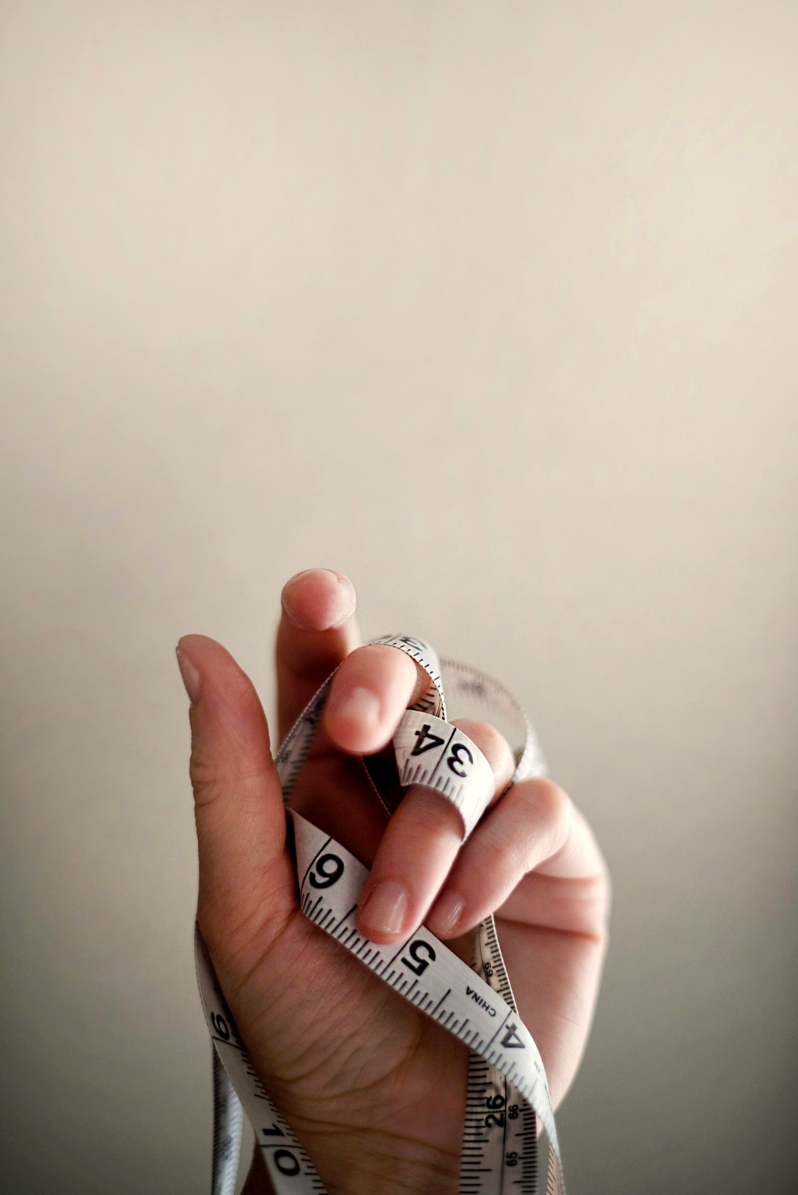 A hand holding a coiled measuring tape
