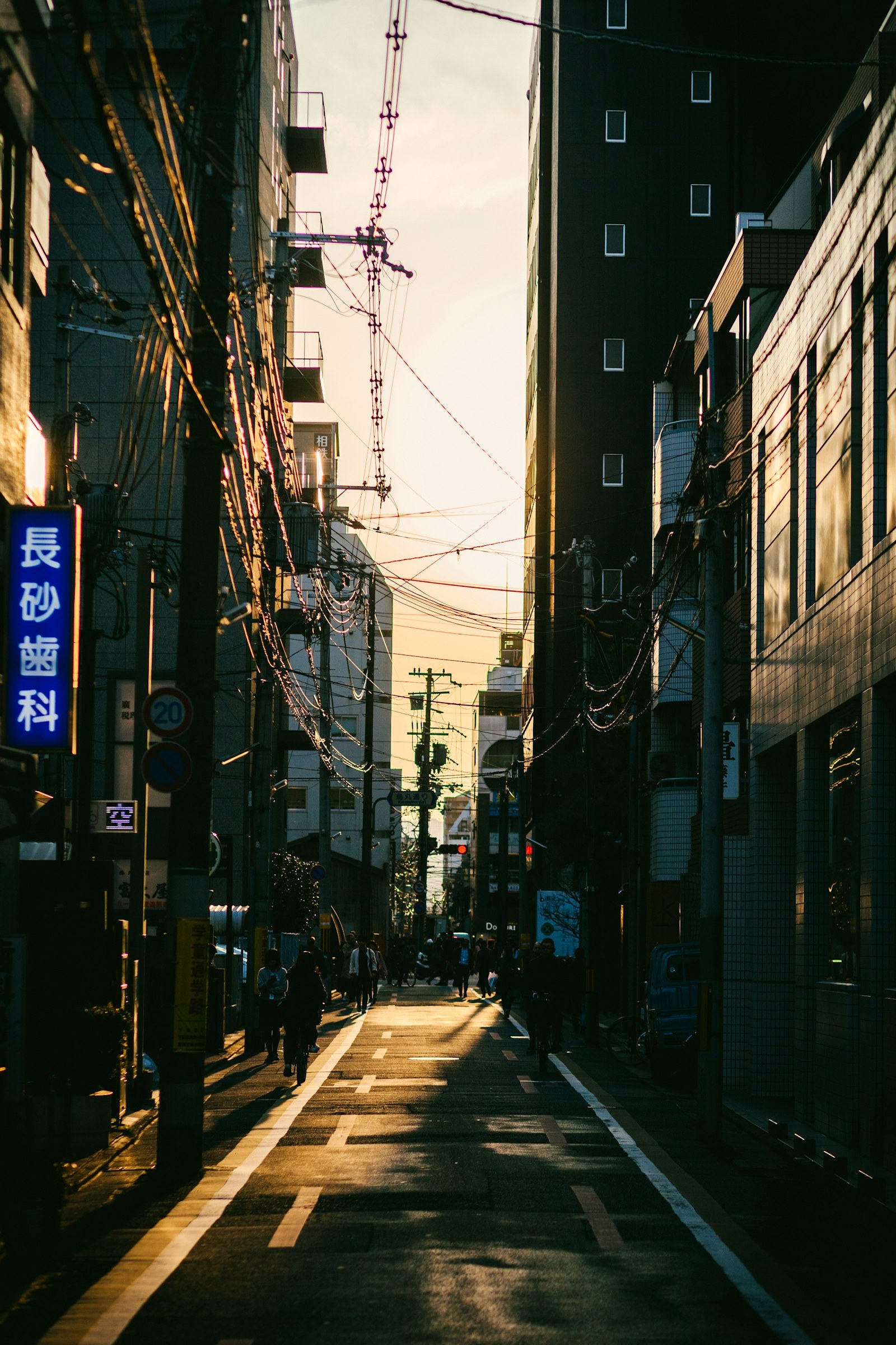 A Japanese backstreet at sunset under tangled wires