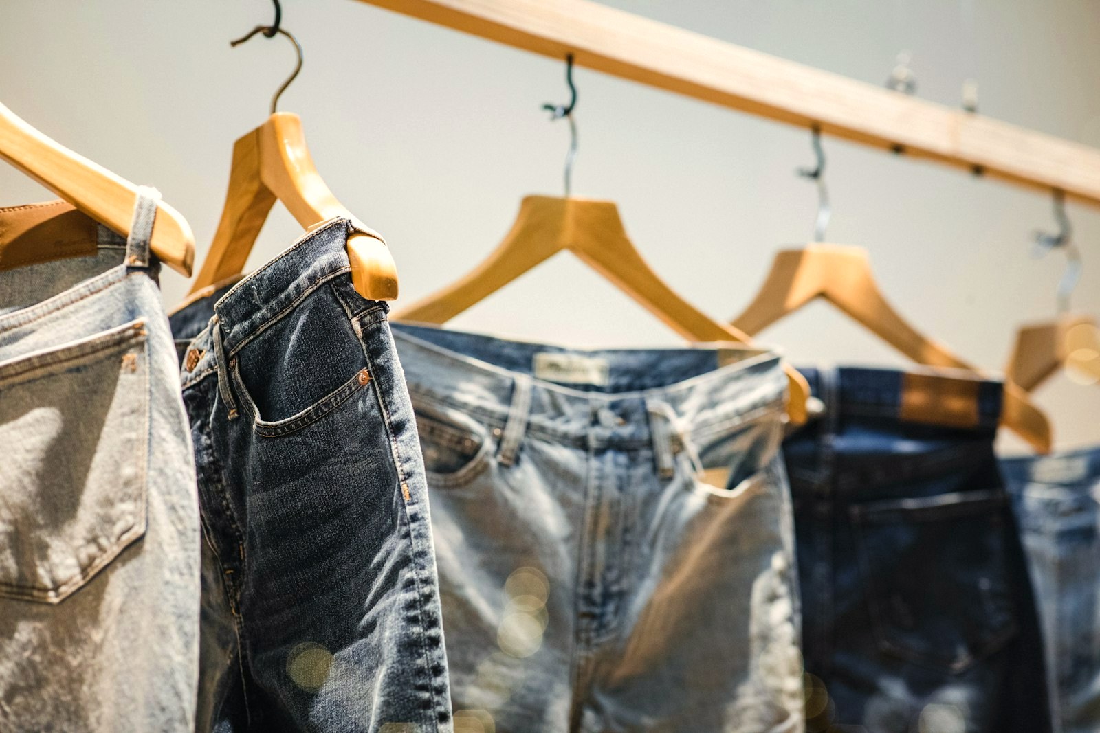 Jeans hanging on wooden hangers