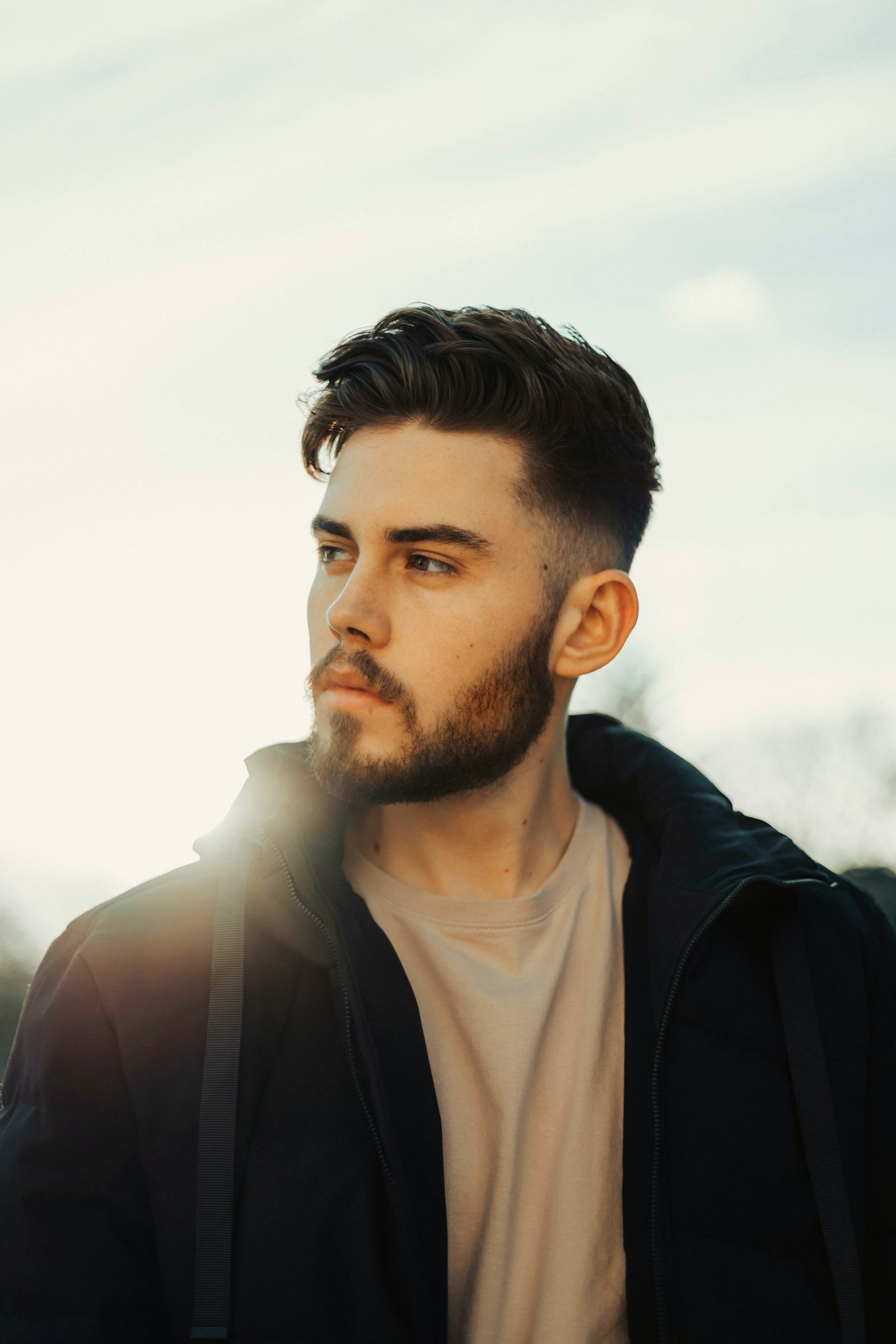 Man with a short beard in warm sunlight wearing a jacket