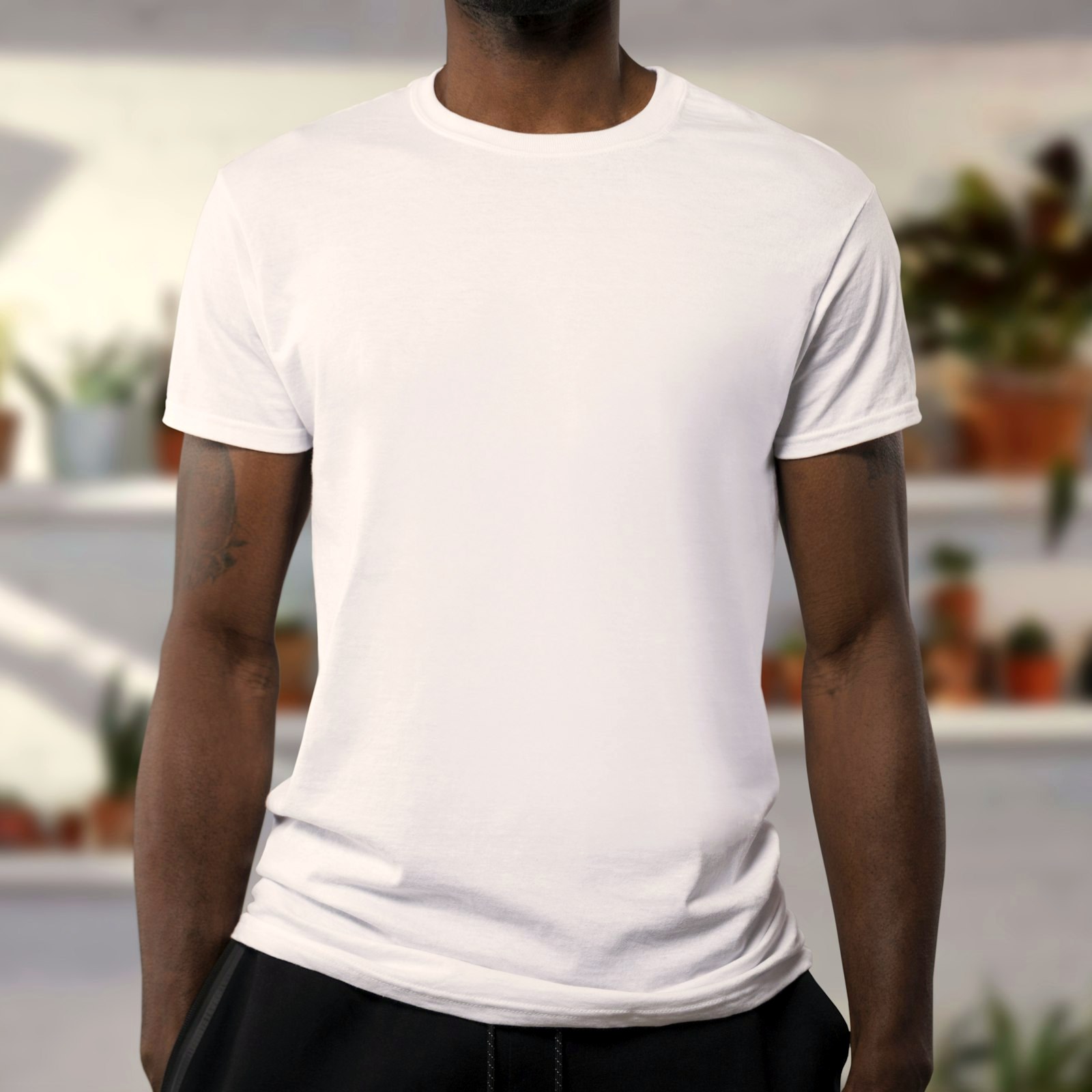 Man wearing a plain white crew neck t-shirt, torso view, soft indoor light