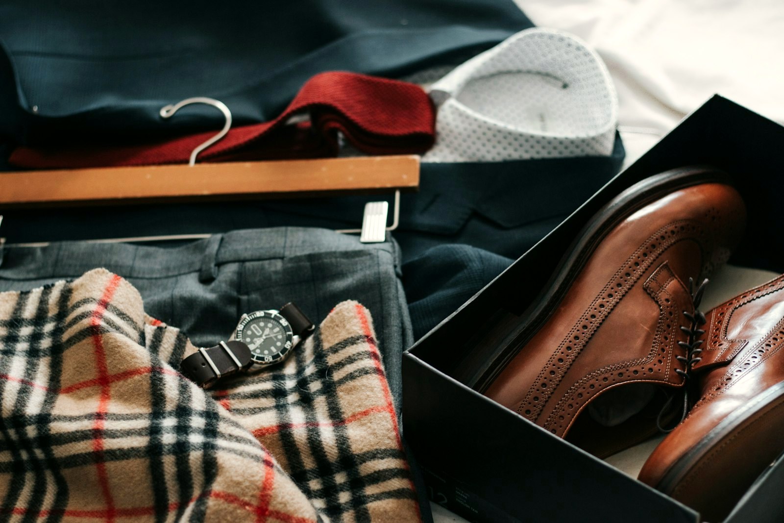 Flat lay of folded trousers with leather shoes