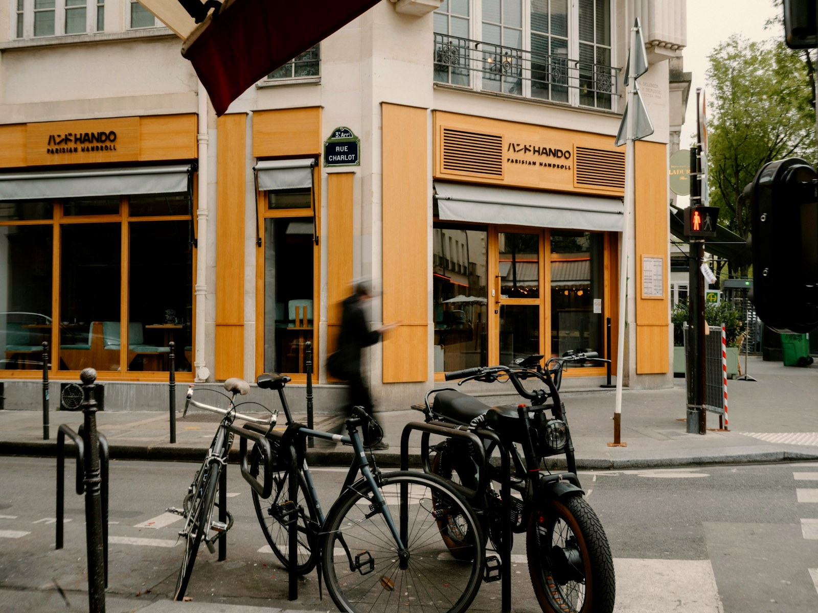 A Marais street corner in Paris, bicycles parked in the foreground, shopfronts behind