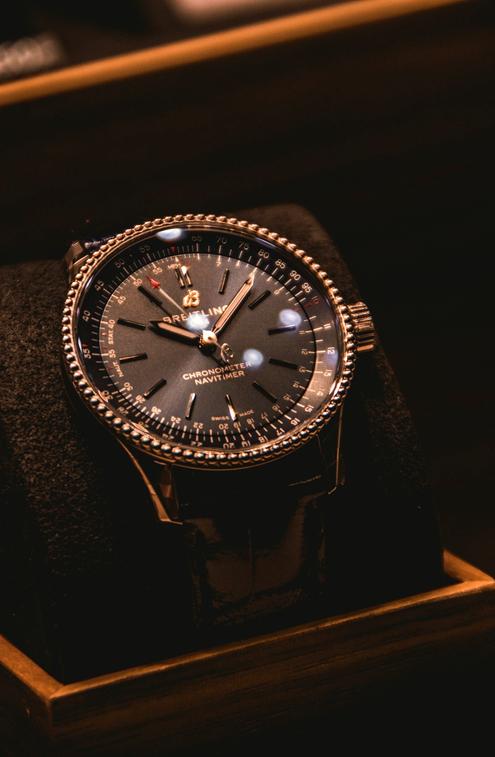 A cased watch in a wooden presentation box, in moody light
