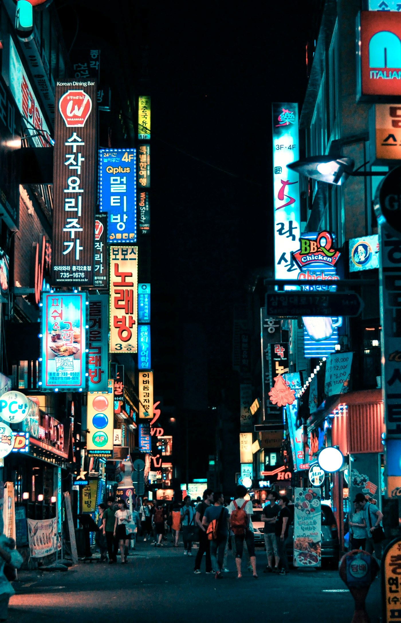 A neon-lit shopping street in Seoul, South Korea, at night