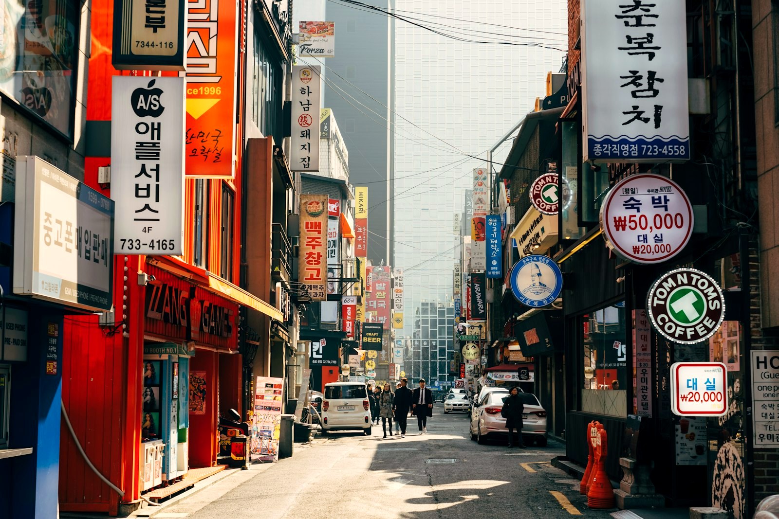 A shopping street in daylight, storefronts in a row