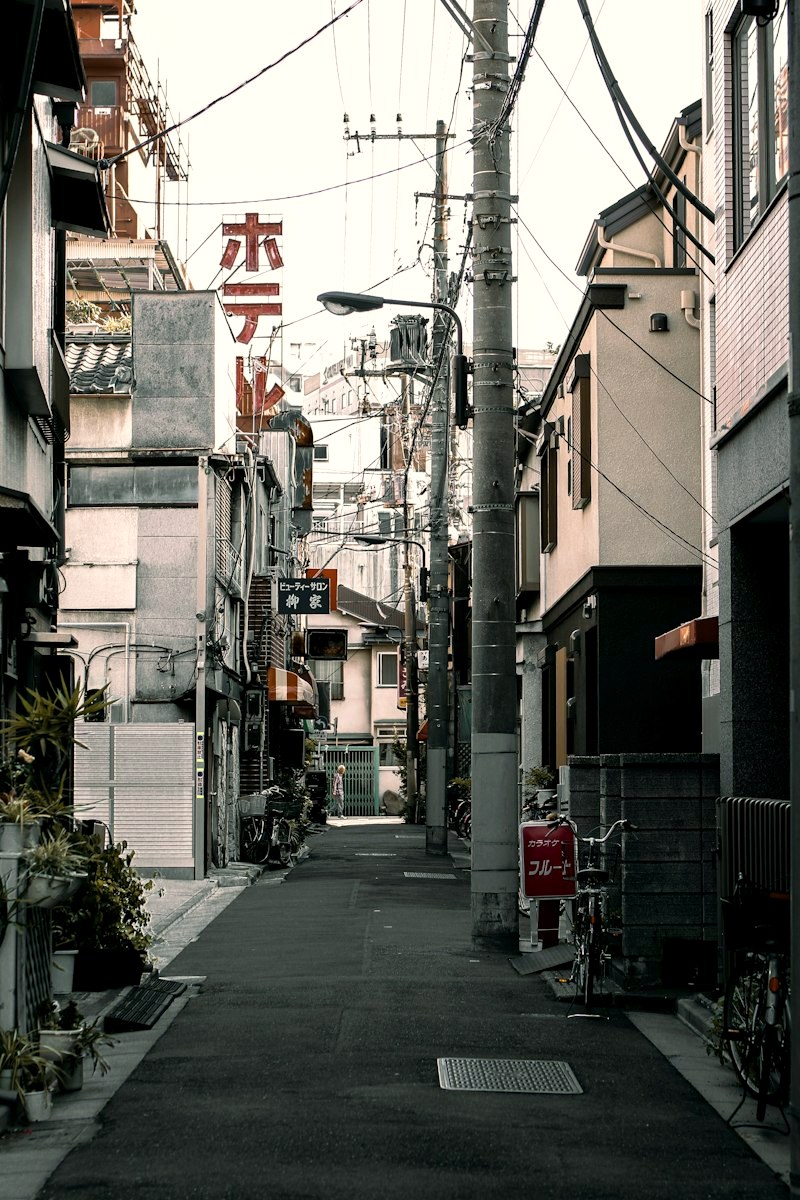 A narrow Tokyo alley lined with signs at dusk