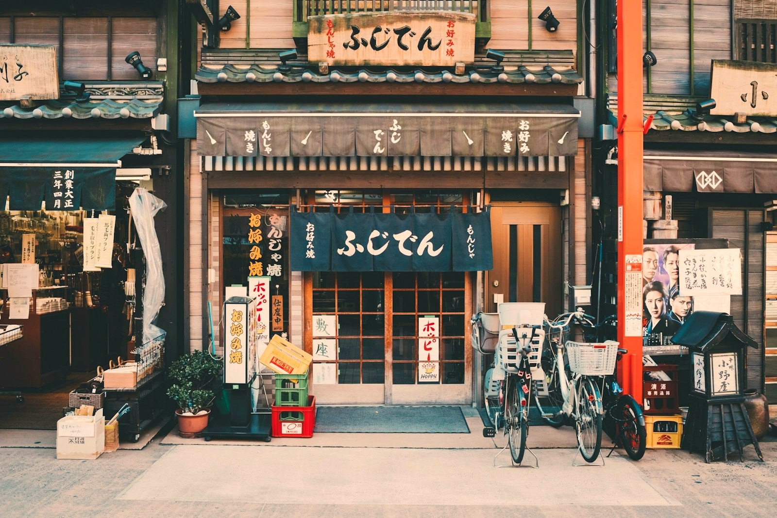 A traditional Tokyo shopfront with noren curtains, hand-painted signage and bicycles