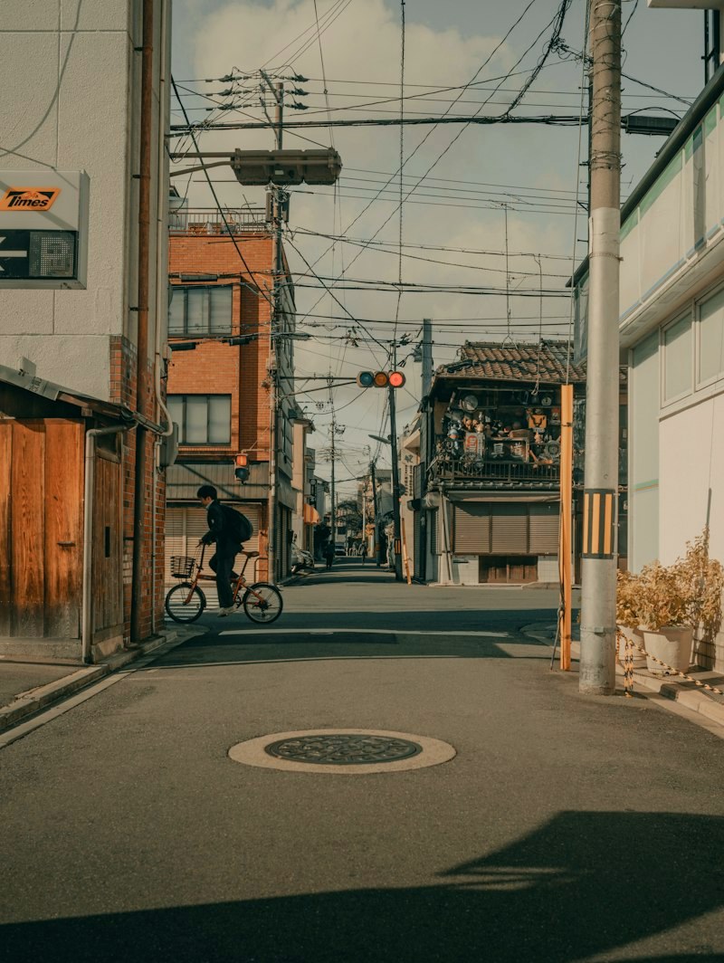 Man in tailored trousers cycling through a Tokyo street