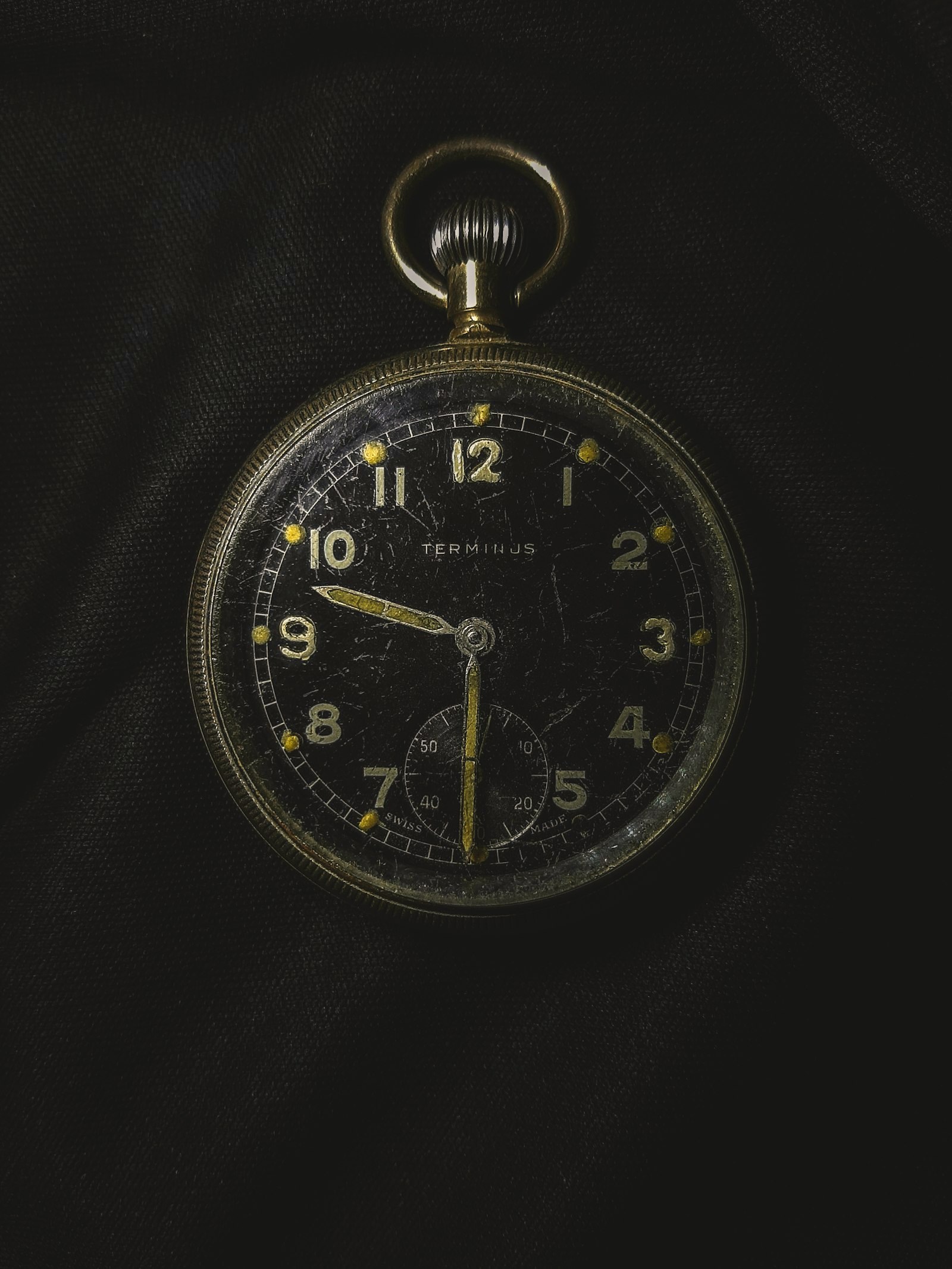 A vintage pocket watch against black, the dark frame the skip gets