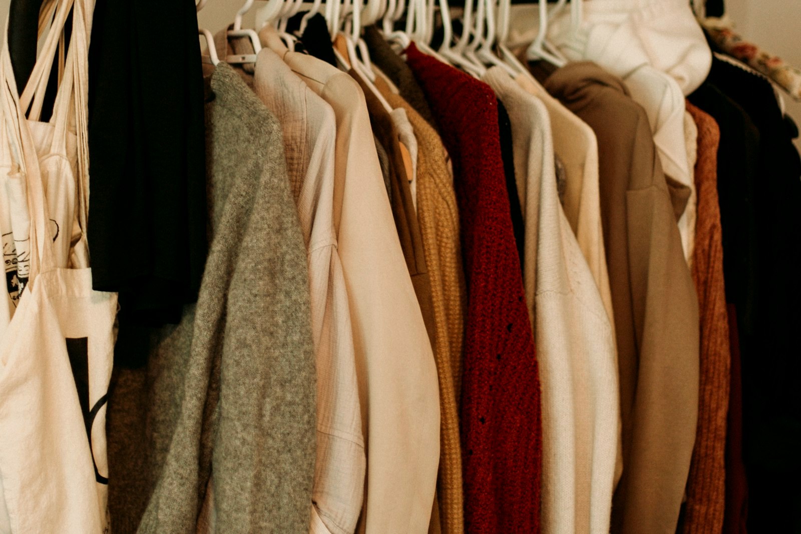 Rail of neutral-toned garments in a wardrobe