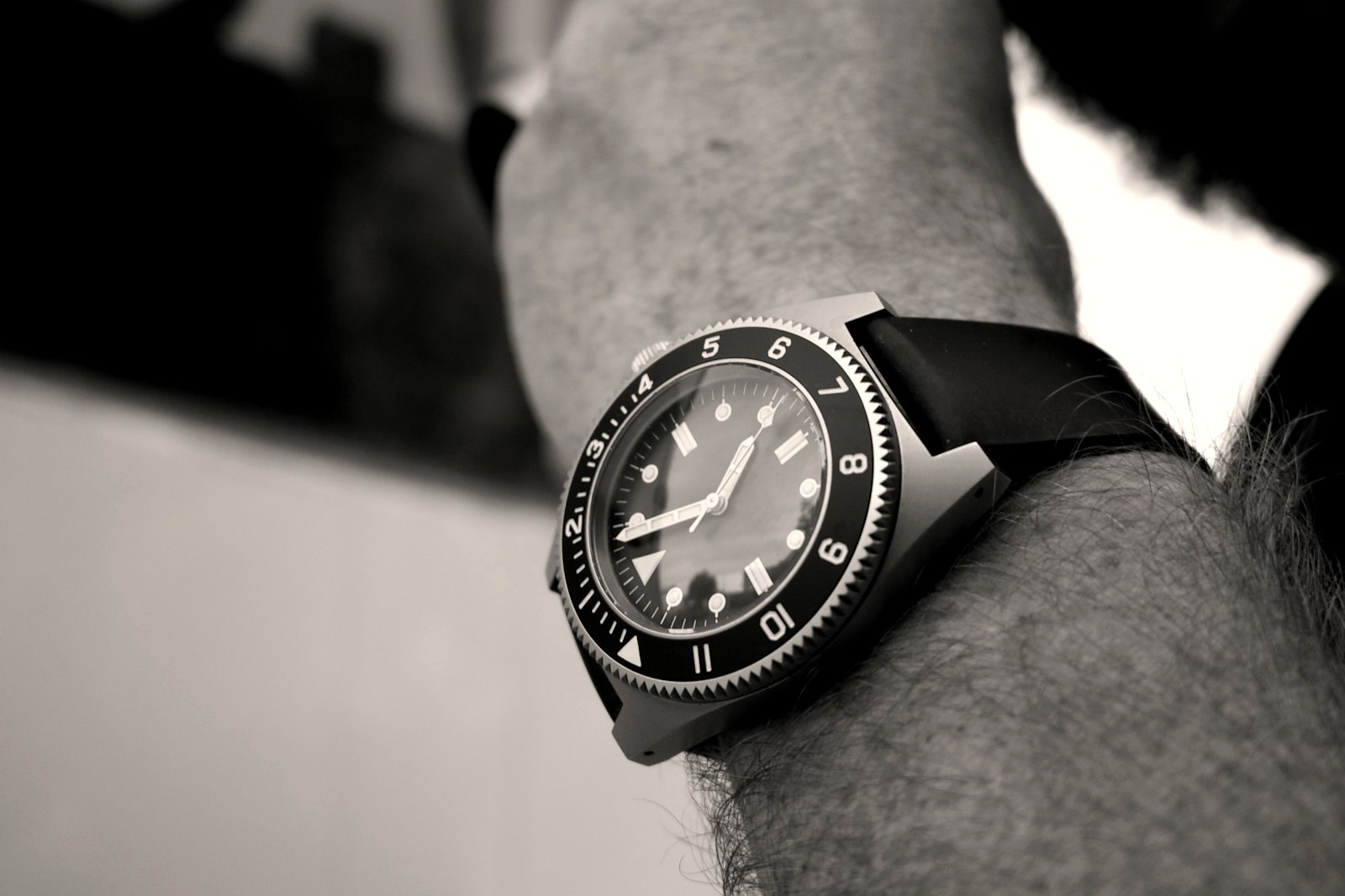 Dive watch with a unidirectional bezel on a wrist, black and white