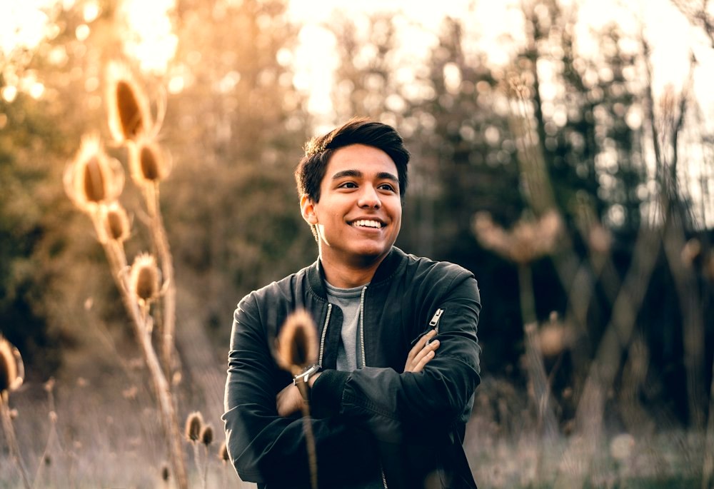 Portrait of a young man in a bomber jacket in soft golden-hour light